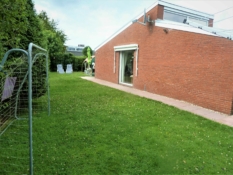 Fotos von Ferienhaus Kolks Huus in Neuharlingersiel zeigen den gepflegten Garten mit der Ostseite des Hauses, Wohnzimmerfenster mit Markise, Fussballtor und Sonnenliegen